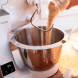 Bosch MUM5XW10 keukenmachine met mengkom en ingrediënten in gebruik, ingrediënt wordt toegevoegd