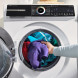 Bosch WGN246A9NL droger in wasruimte met persoon die wasmiddeldispenser vult boven geopende deur