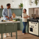 Falcon Classic 2026 100 Inductie ingebouwd in groene keuken met twee personen bij het fornuis