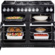 Falcon Nexus SE 110 Gas fornuis zwart, beide ovens geopend met voedsel en grillplaat zichtbaar