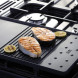 Falcon Professional+ 100 Gas gaskookplaat detail met vleessteaks en citroenschijven tijdens koken