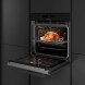 Inventum IOM6035GT geopende oven met geroosterde kip op draaihaak in keukensituatie