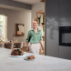 Miele H 2861-1 B 125 Edition oven geïnstalleerd in moderne keuken met geopende deur en brood in ovenkamer