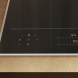 Miele KM8665FR inductiekookplaat detail linkerkant bedieningspaneel met symboolknoppen en rechterkant display met vermogensindicatoren, in inbouwsituatie