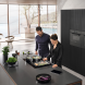 Miele KMDA 7473-1 FL Silence ingebouwd in moderne keuken, twee personen aan het koken op het apparaat