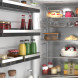 Siemens KS36NEWCM koelkast interieur close-up met glasplateaus, flessen, potten en taart