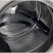 Whirlpool wasmachine geopende deur detail trommel met perforatiegaten en zwart blad
