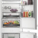 Whirlpool WHK2 5322 B4E inbouw koel-vriescombinatie met geopende deuren, gevuld met voedsel