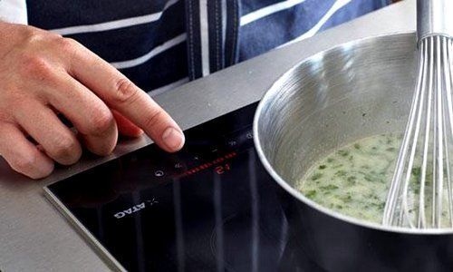 Bediening van een inductiekookplaat tijdens het koken
